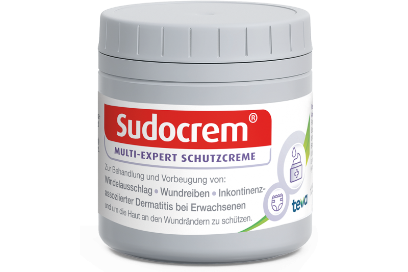 Grau-weiße Dose von Sudocrem mit rotem Logo und Informationen zur Verwendung der Schutzcreme.